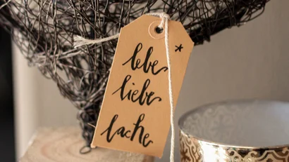 Drahtherz mit Schild lebe liebe lache und dekorative Kerze auf Holzblock