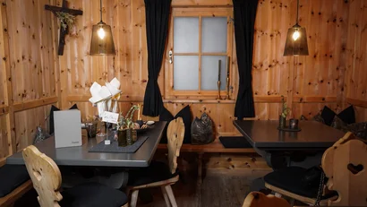 Gemütlicher Holzesstisch mit Stühlen und Holzfenster mit Vorhängen