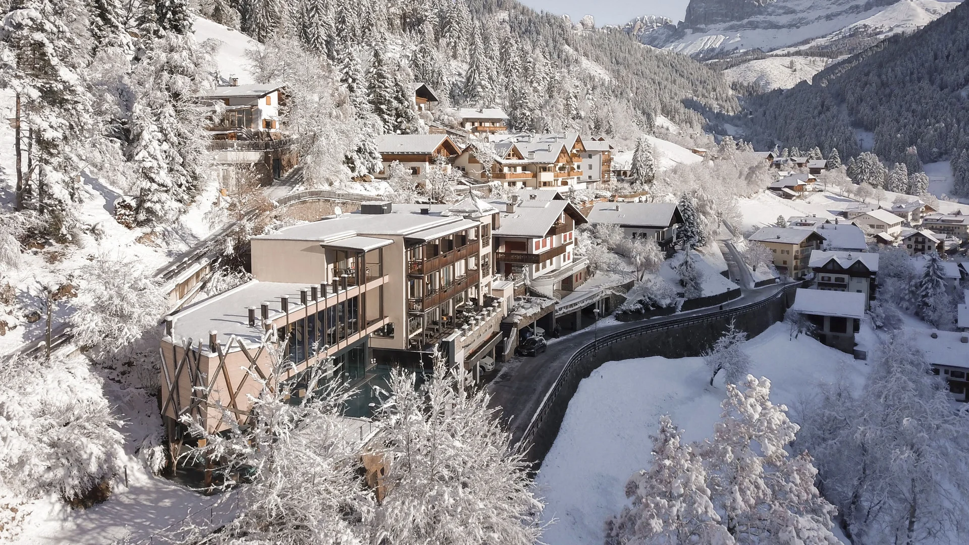 Paesaggio invernale con villaggio innevato e montagne sullo sfondo
