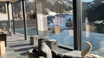 Modernes Wohnzimmer mit Panoramafenster und Blick auf verschneite Berge