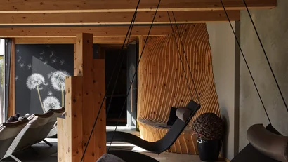 Gemütlicher Ruheraum mit Schaukelliegen und Holzdecke in einem Spa