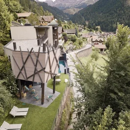 Moderne Berghütte mit Garten und Blick auf bewaldete Berge und Dorf