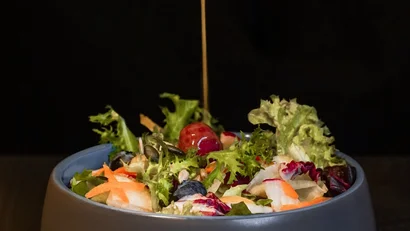 Frischer gemischter Salat mit Dressing in einer grauen Schale