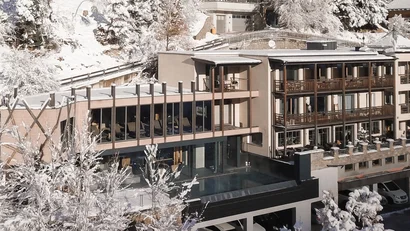 Modernes Hotel umgeben von verschneiten Bäumen in winterlicher Berglandschaft