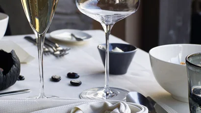 Eleganter gedeckter Tisch mit Weißwein und Serviette im Restaurant Infinitich