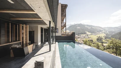 Moderner Infinity-Pool mit Bergblick an einem sonnigen Tag