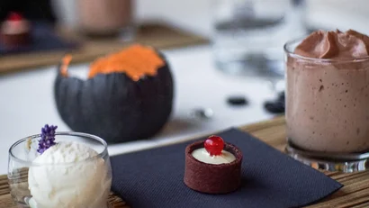 Verschiedene Desserts auf Holzbrett auf weißem Tisch